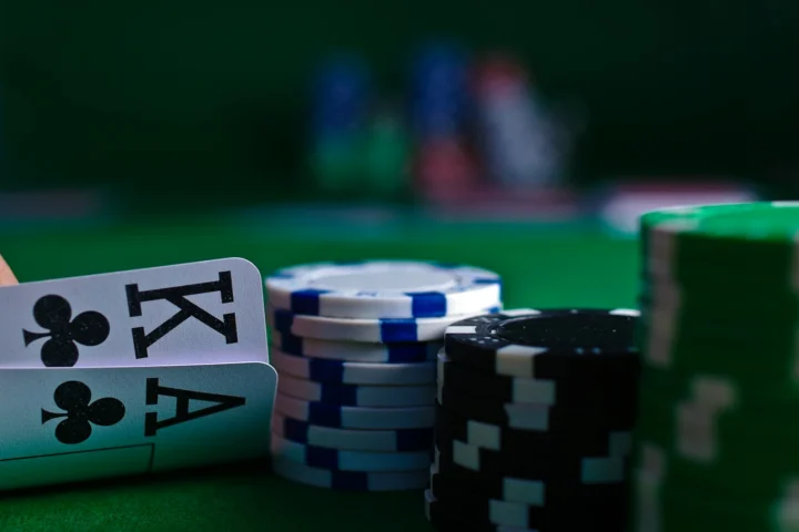 Playing cards and stacks of chips on a green table